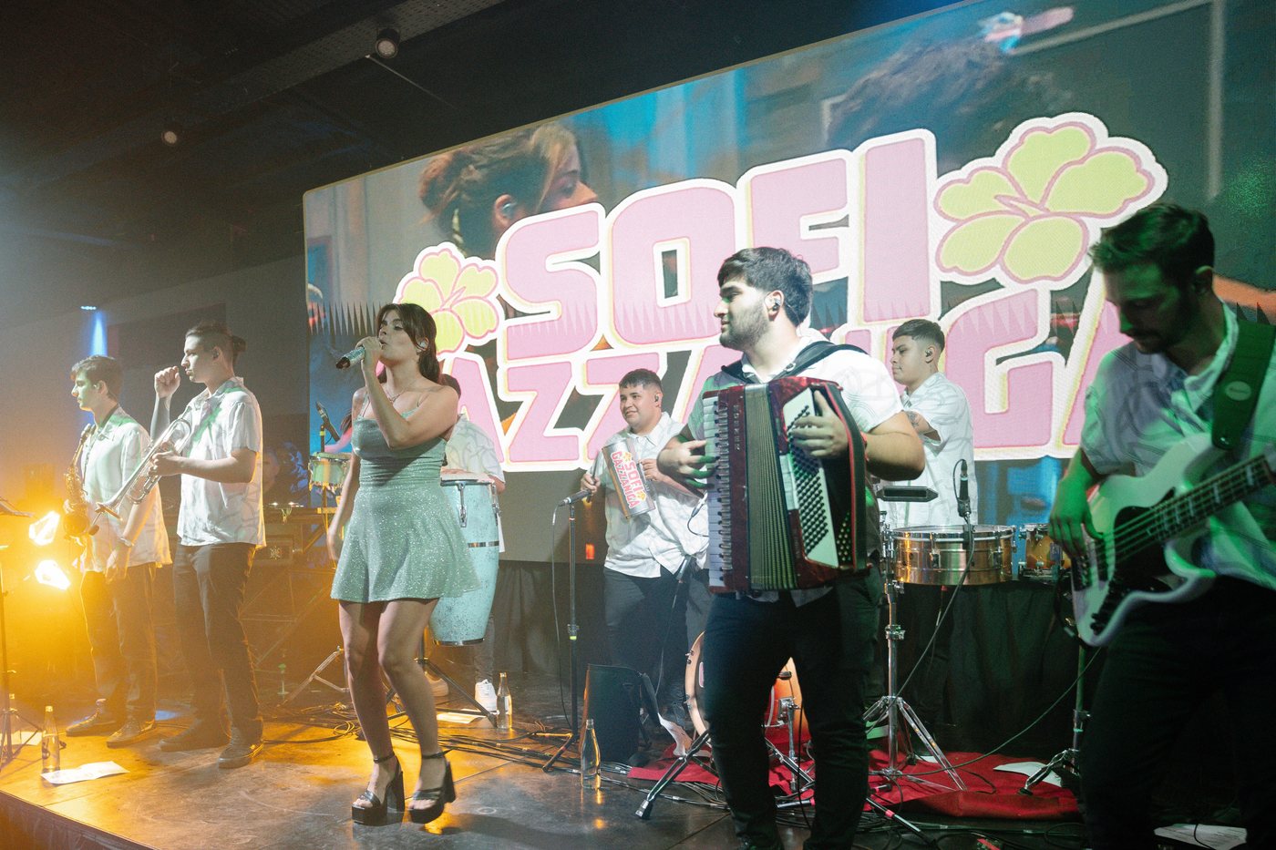 Cantante con su banda en vivo &mdash;acorde&oacute;n, vientos y percusi&oacute;n&mdash; animando la pista de una fiesta