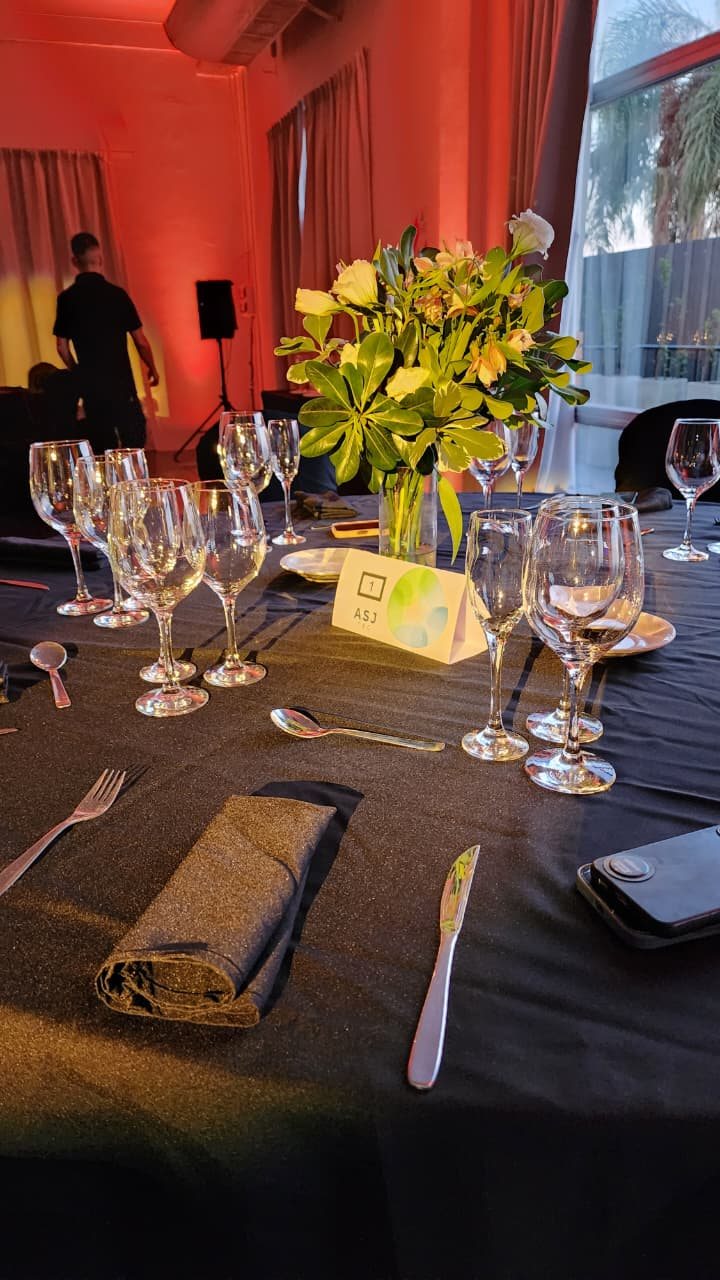 Cena corporativa con mesas montadas e iluminación cálida
