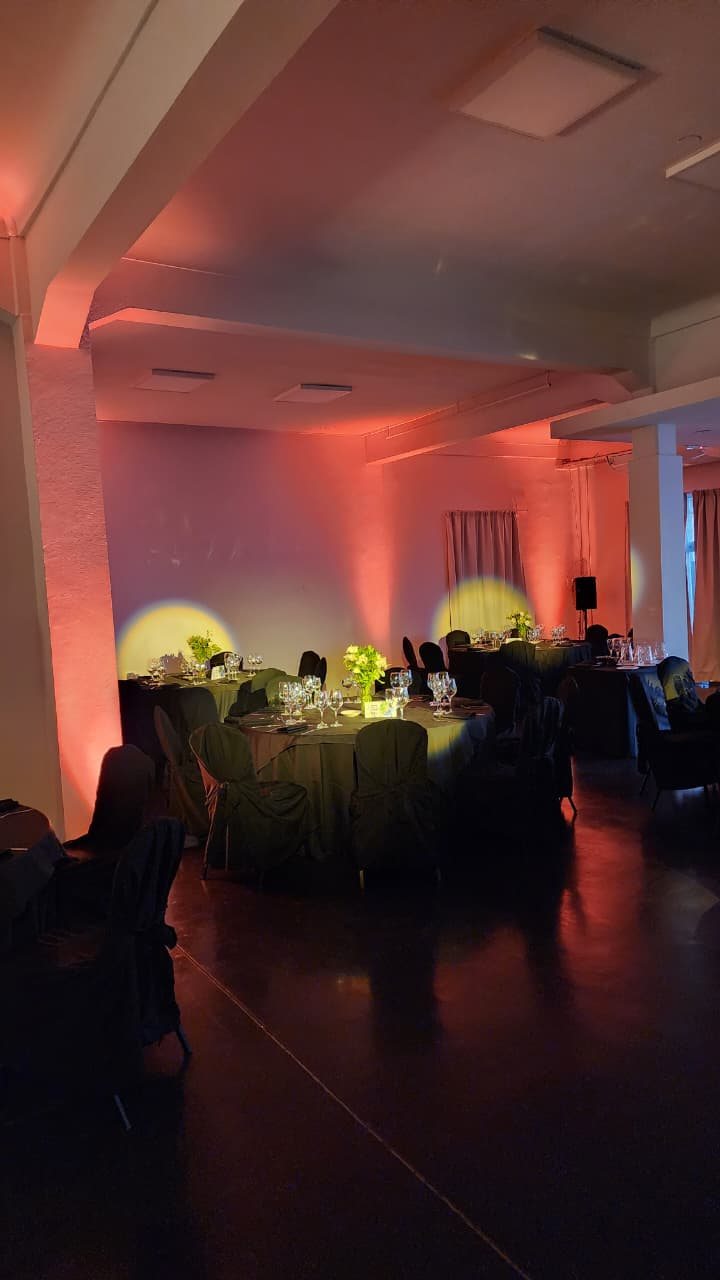 Salón montado para una cena corporativa con iluminación