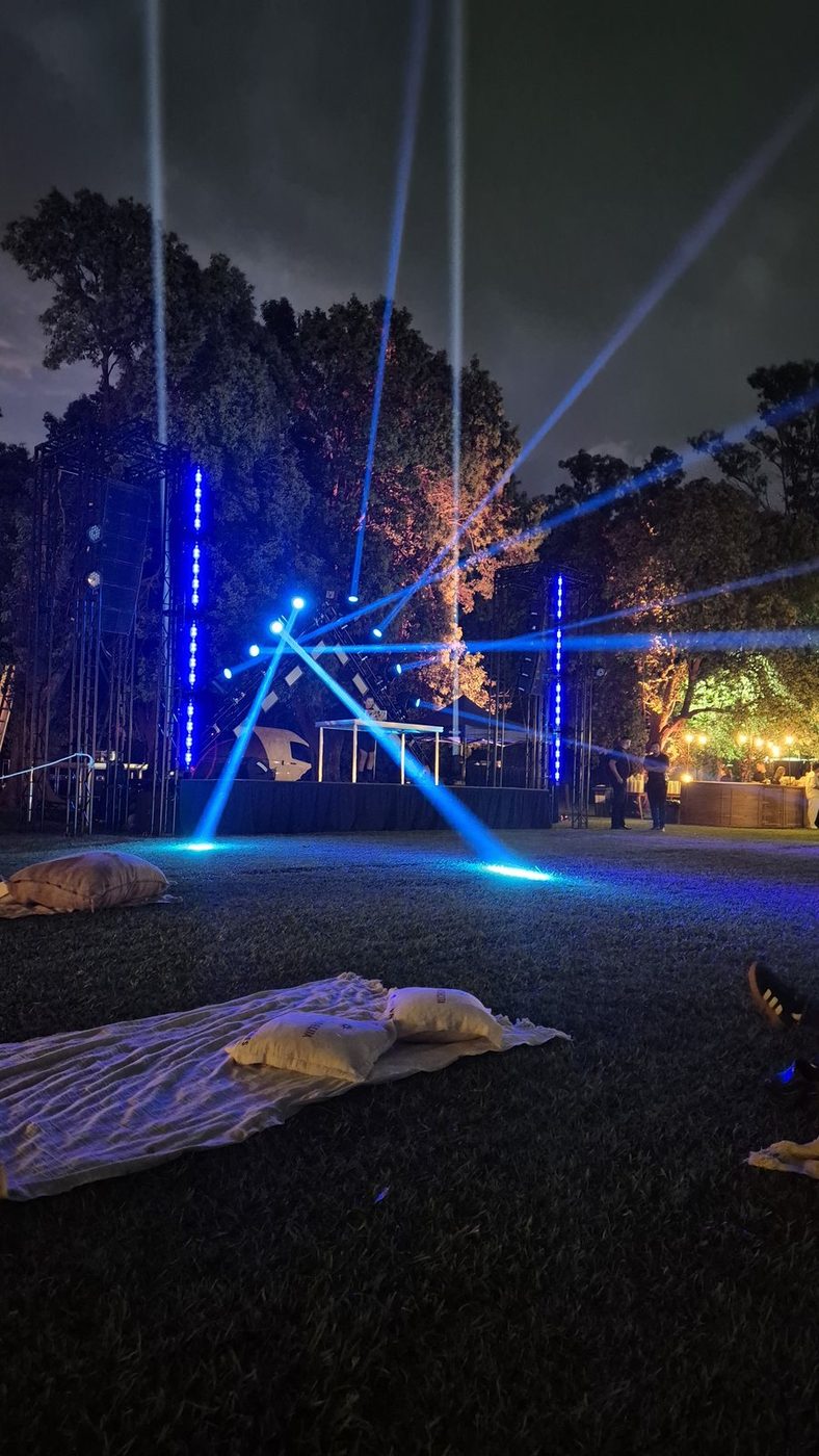 Haces de luz azules iluminando el parque y los espacios lounge de noche