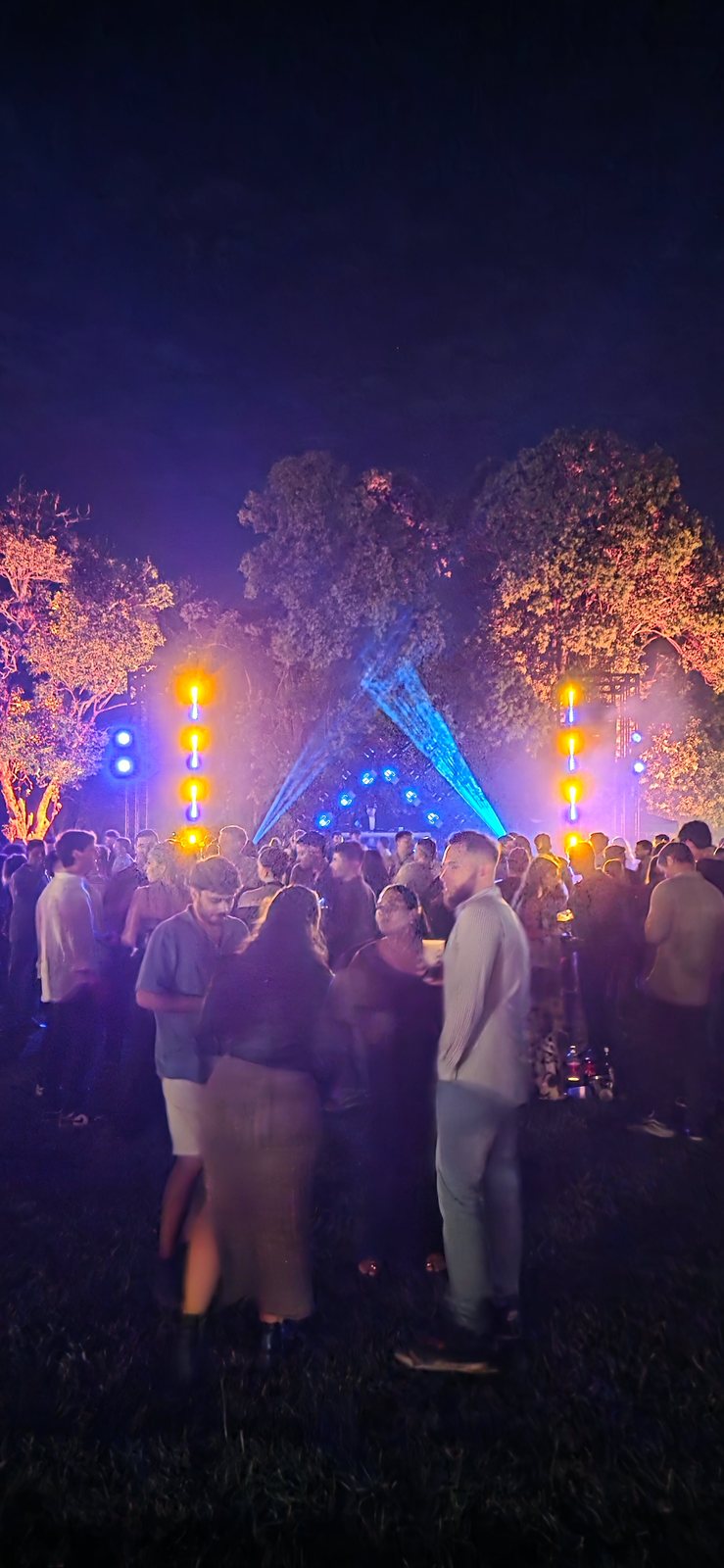 Multitud de 1200 personas bailando de noche frente al escenario iluminado
