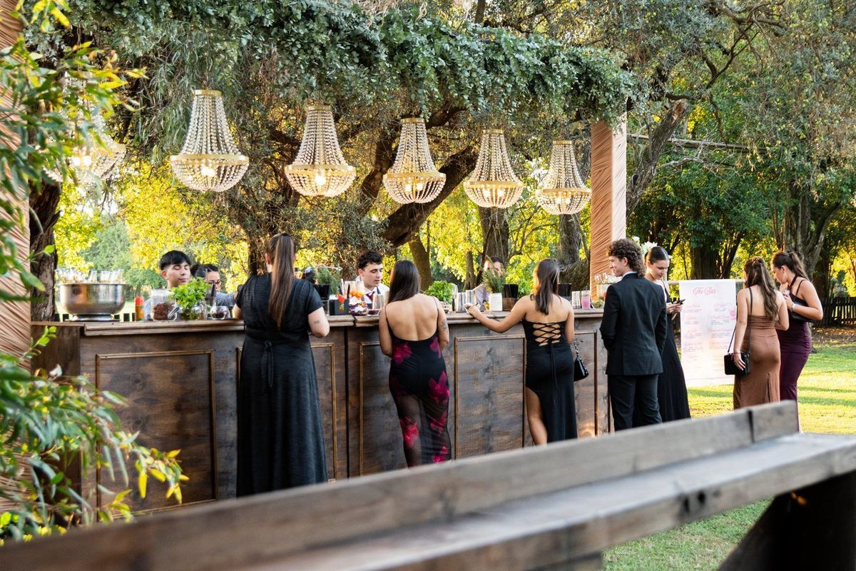 Barra de tragos con colgantes iluminados en el parque