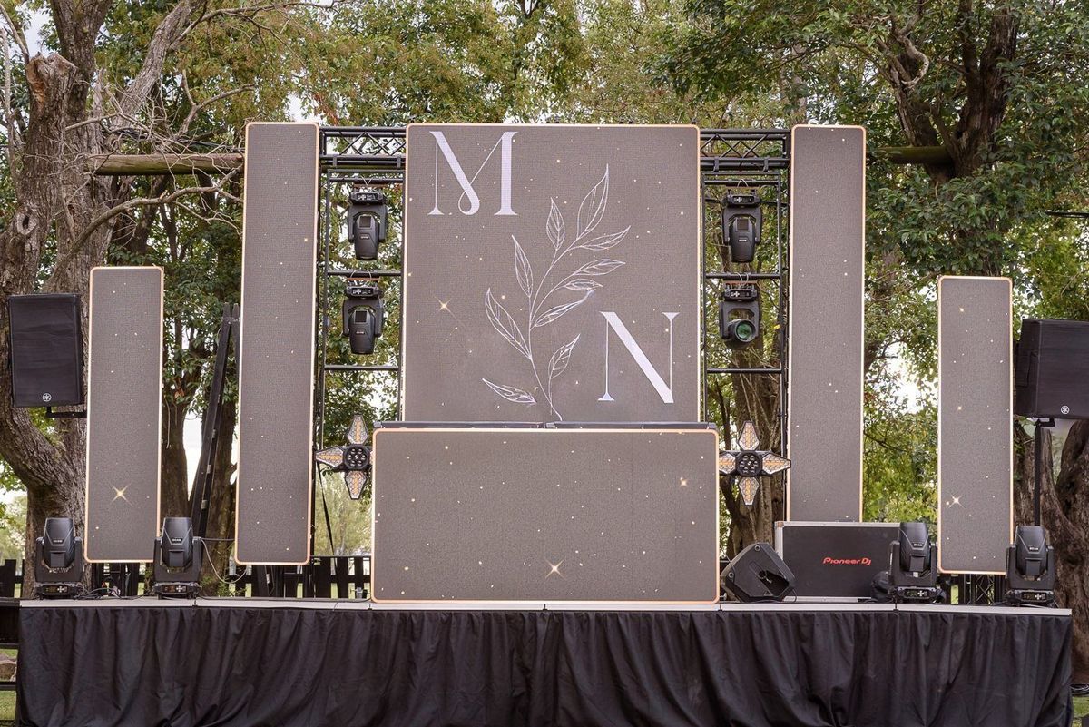 Cabina de DJ con backdrop iluminado y monograma