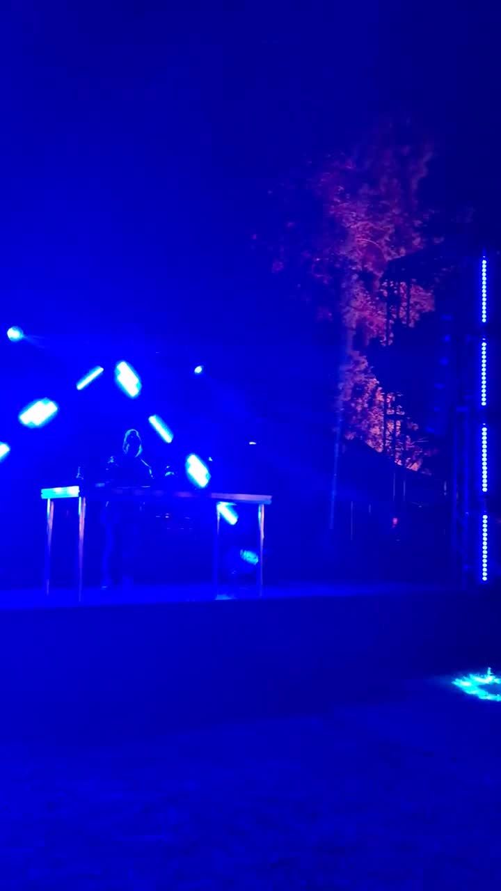 La cabina de DJ en acci&oacute;n de noche, con la pir&aacute;mide de paneles LED encendida en La Tardecita