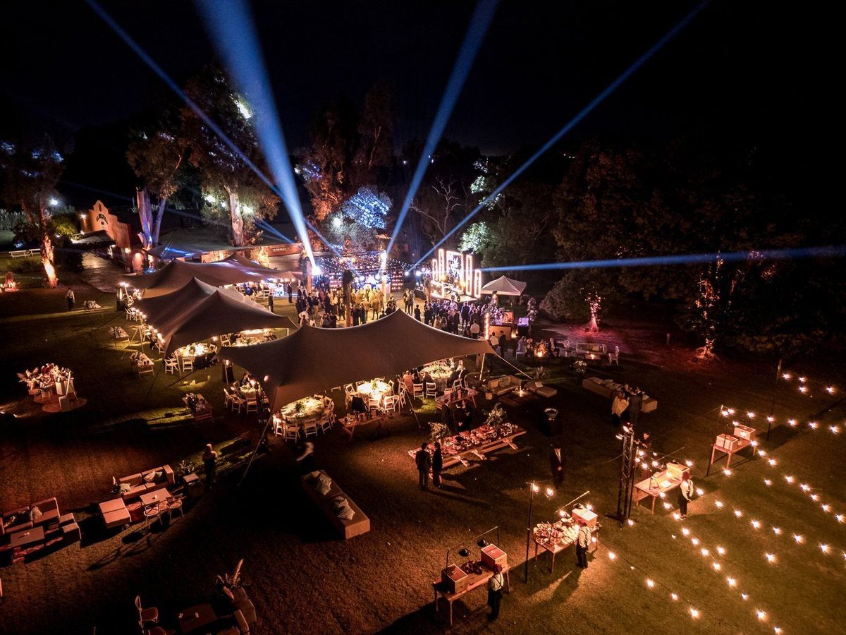 Predio de una fiesta iluminado de noche con buscacielos