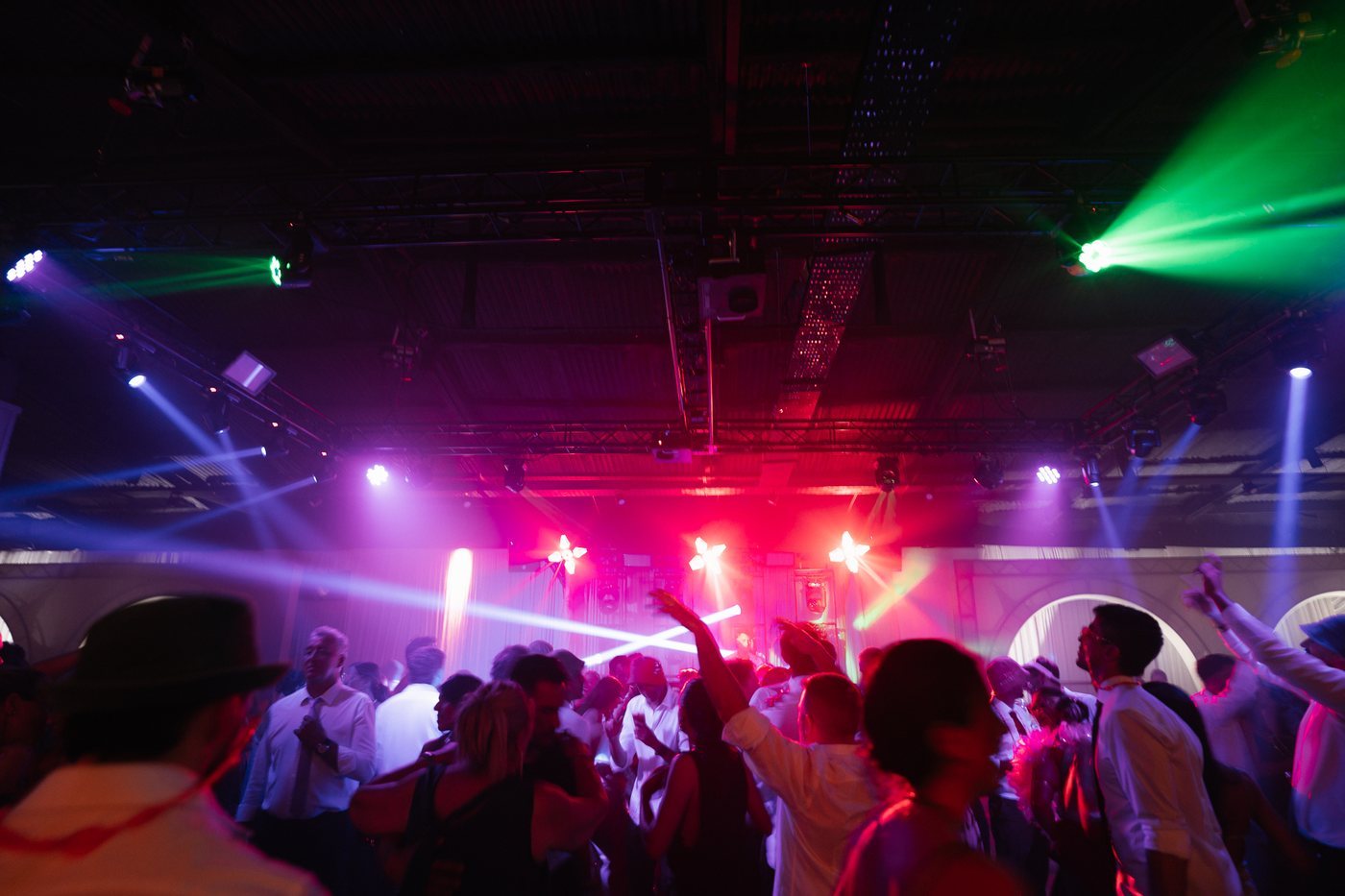 Pista de baile llena con cabezas móviles y haces de luz