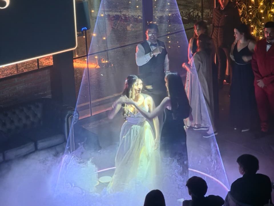 Quinceañera bailando el vals dentro del cono de láser con humo bajo en su fiesta de 15